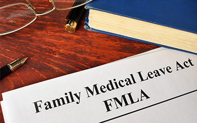 family medical leave act on paper with book glasses and pens